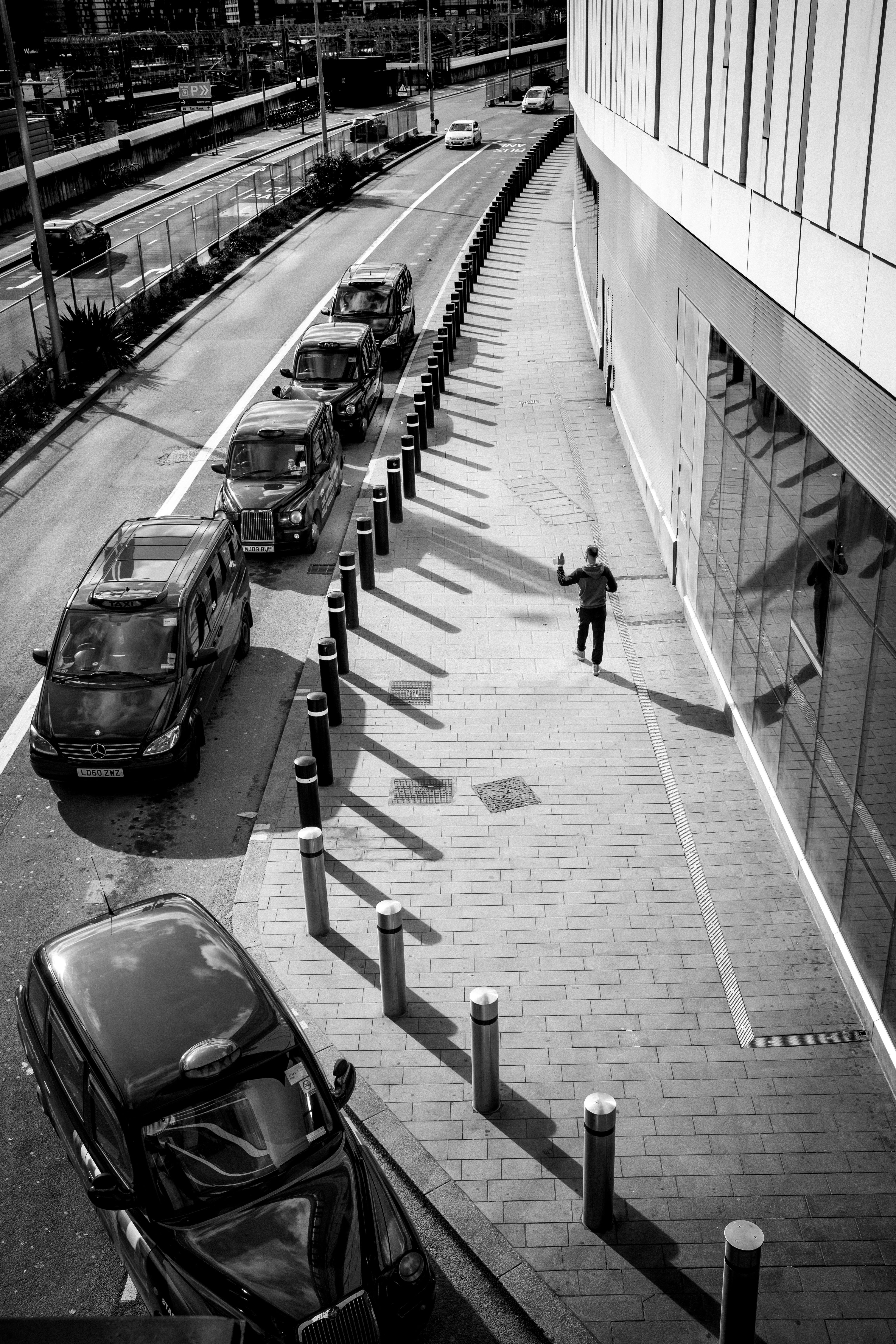 grayscale photo of people walking on sidewalk